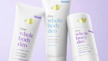 Three Dove ‘Whole Body Deo’ deodorant products displayed against a soft purple background. The products include two tubes labelled ‘invisible cream’ for odour control with vitamins – one coconut and vanilla scented and one unscented – and a white anti friction stick also in the coconut and vanilla scent. Each item features the Dove gold bird logo and clean, minimalist packaging.